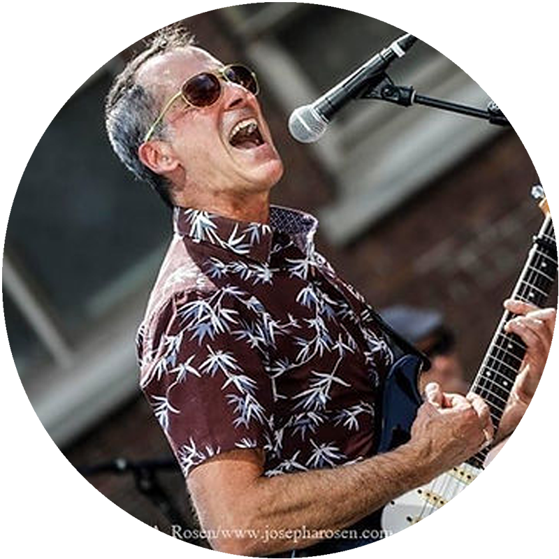 Dave Keller performing with microphone and guitar